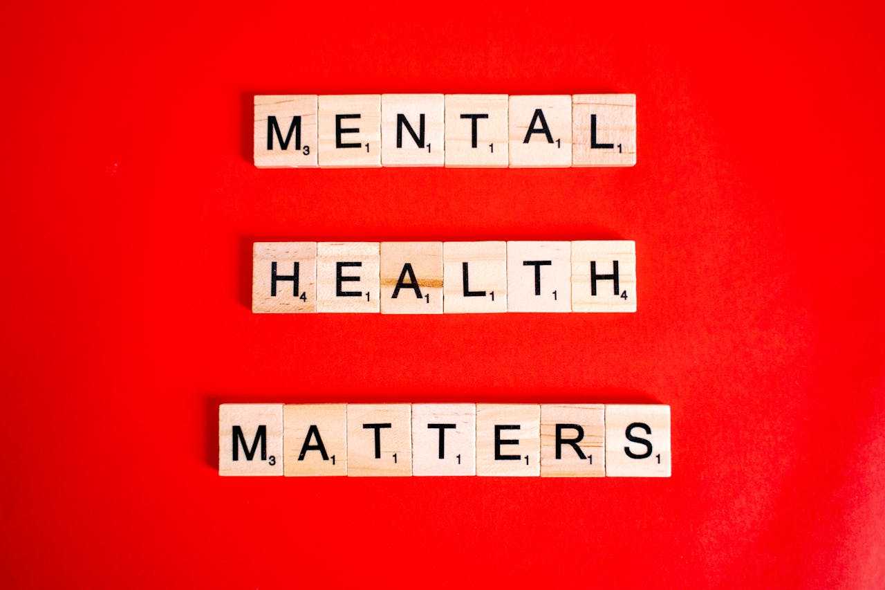 Wooden tiles spelling 'Mental Health Matters' on a vivid red background.